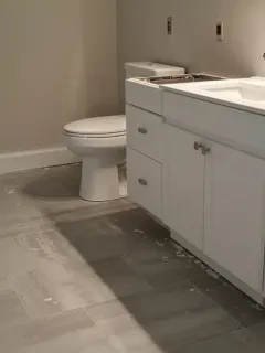 Modern bathroom renovation with new tile flooring and contemporary vanity installed in a US home