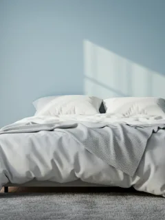 Peaceful blue bedroom with white bedding designed for optimal sleep