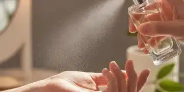 Eau de Parfum vs. Eau de Toilette: Was ist besser für Sie? Nahaufnahme einer Person, die Parfüm auf ihr Handgelenk sprüht.
