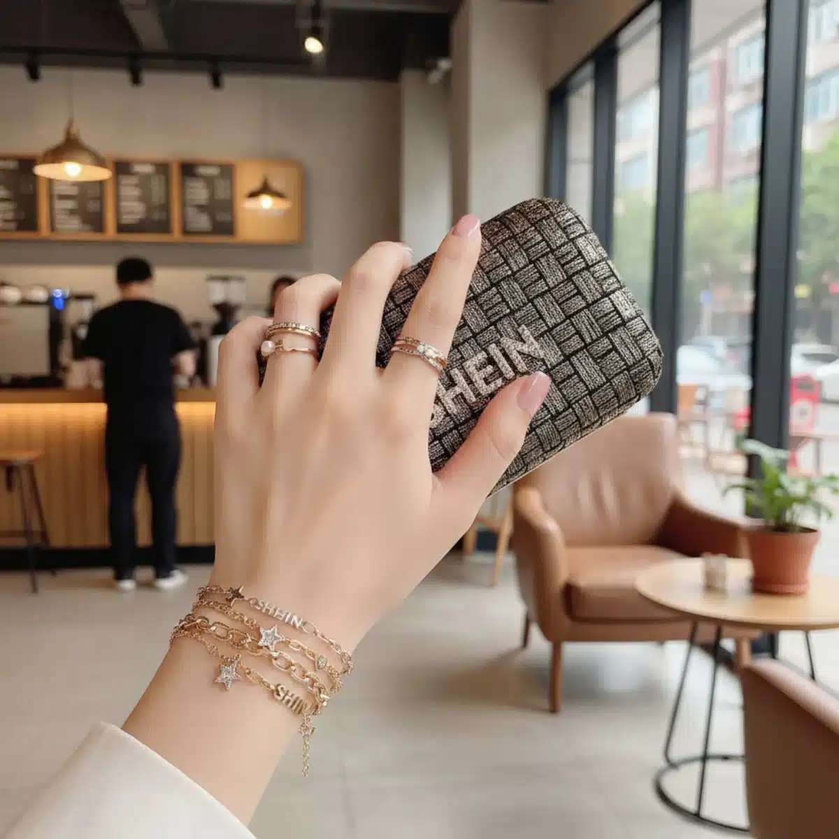Nahaufnahme von Händen mit SHEIN Ringen, Armbändern und Clutch