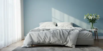 Peaceful blue bedroom with white bedding designed for optimal sleep