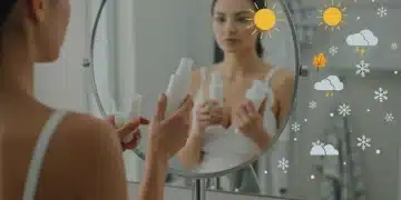 Woman adjusting skincare routine with seasonal products in bathroom