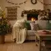 Gemütliches Wohnzimmer mit nachhaltiger Weihnachtsdekoration 2026: Trockenorangen, Holzschmuck und LED-Lichter für ein umweltfreundliches Fest.